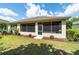 Back exterior with a screened-in porch, mulch beds, and well-maintained lawn in a private backyard at 7263 Sw 99Th Cir, Ocala, FL 34481
