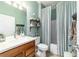 Bathroom featuring a single vanity, mirror and wood look shelves with décor, plus a shower-tub with striped curtain at 7263 Sw 99Th Cir, Ocala, FL 34481