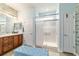Bathroom featuring wood-look accent wall, vanity with cabinets, shower, and linen closet at 7263 Sw 99Th Cir, Ocala, FL 34481