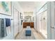 Hallway leading to primary ensuite bath with double vanity, linen storage and glass enclosed shower at 7263 Sw 99Th Cir, Ocala, FL 34481