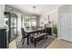 Elegant dining room featuring a modern light fixture, stylish decor, and large windows offering plenty of natural light at 7263 Sw 99Th Cir, Ocala, FL 34481
