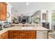 Open concept kitchen with breakfast bar looking into the living room with stainless dishwasher and sink at 7263 Sw 99Th Cir, Ocala, FL 34481