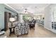 Open-concept living room with a large window, hardwood floors, comfortable seating, and a view of the kitchen at 7263 Sw 99Th Cir, Ocala, FL 34481