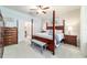 Main bedroom with en suite bath featuring a four-poster bed, neutral decor and a ceiling fan at 7263 Sw 99Th Cir, Ocala, FL 34481