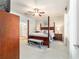 Bright main bedroom featuring a four-poster bed, ceiling fan and ensuite bathroom with shower at 7263 Sw 99Th Cir, Ocala, FL 34481
