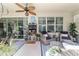 Relaxing screened patio furnished with wicker chairs, a ceiling fan, and view to the outdoor patio at 7263 Sw 99Th Cir, Ocala, FL 34481