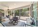 Covered patio with an outdoor dining table, seating area, ceiling fan, and views of the landscaped backyard at 7263 Sw 99Th Cir, Ocala, FL 34481