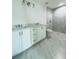 Bright bathroom featuring a double vanity with quartz countertops and a modern walk-in shower at 7292 Hemlock Loop, Ocala, FL 34472