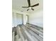 A bedroom featuring wood-look floors, bi-fold closet doors, and natural light at 7292 Hemlock Loop, Ocala, FL 34472