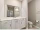 Bright bathroom featuring a vanity with storage, large mirror, and a toilet at 7987 Sw 89Th Cir, Ocala, FL 34481