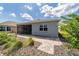 Home exterior features a screened-in patio, brick patio, and landscaped backyard, and a view of adjacent home at 7987 Sw 89Th Cir, Ocala, FL 34481
