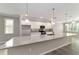 Modern kitchen featuring white cabinets, stainless steel appliances, quartz countertops, and an expansive island at 7987 Sw 89Th Cir, Ocala, FL 34481