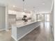 Modern kitchen showcasing a large island, stainless steel appliances, and stylish pendant lighting at 7987 Sw 89Th Cir, Ocala, FL 34481