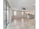 Bright, open-concept living area with tile flooring, ceiling fan, and sliding glass doors to the outside at 7987 Sw 89Th Cir, Ocala, FL 34481