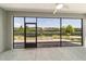 View of the screened patio with fan, concrete floor, and an extended brick-paved terrace with backyard view at 7987 Sw 89Th Cir, Ocala, FL 34481