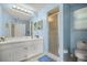 Blue bathroom featuring a shower with glass doors, and a single sink vanity at 8137 Sw 117Th Loop, Ocala, FL 34481