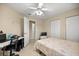 This bedroom features a ceiling fan, tile floors, and space for a desk near the closets at 8137 Sw 117Th Loop, Ocala, FL 34481