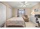 Cozy bedroom with a patterned quilt, comfy armchair, a ceiling fan, and tile flooring at 8137 Sw 117Th Loop, Ocala, FL 34481