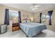 Comfortable bedroom featuring ample natural light, tile flooring, ceiling fan, and a queen sized bed at 8137 Sw 117Th Loop, Ocala, FL 34481