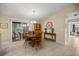 Charming dining area with a round wooden table, adjacent to a sunroom and hallway at 8137 Sw 117Th Loop, Ocala, FL 34481