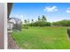 Expansive backyard with lush lawn, mature trees, and screened-in patio with putting green at 8809 Sw 61St Loop, Ocala, FL 34481