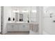 Bright bathroom features a double vanity, white cabinetry, large mirror, and glass shower at 8809 Sw 61St Loop, Ocala, FL 34481