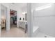Bathroom with double vanity, open closet, and bright white tiled shower at 8809 Sw 61St Loop, Ocala, FL 34481