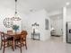 Cozy dining area featuring a wooden table, chandelier, and a view of the front entry at 8809 Sw 61St Loop, Ocala, FL 34481
