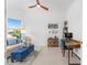 Bright living room with blue accents, ceiling fan, and large windows at 8809 Sw 61St Loop, Ocala, FL 34481