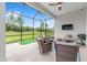 The screened patio features ample seating, a ceiling fan, and a putting green at 8809 Sw 61St Loop, Ocala, FL 34481
