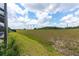 Expansive grassy backyard behind a home under a bright blue sky at 9777 Sw 63Rd Loop, Ocala, FL 34481
