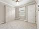 Bedroom with a fan, carpeted floors, murphy bed and a window with decorative curtains at 9777 Sw 63Rd Loop, Ocala, FL 34481