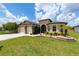 Inviting home with manicured lawn, mature landscaping, stone accents and a spacious driveway leading to a two-car garage at 9777 Sw 63Rd Loop, Ocala, FL 34481