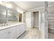 Elegant bathroom with double sink vanity, stylish tiled floor, and glass-enclosed shower at 9777 Sw 63Rd Loop, Ocala, FL 34481