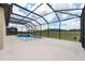Backyard featuring a screened-in pool with a hot tub overlooking a lush green landscape at 9777 Sw 63Rd Loop, Ocala, FL 34481