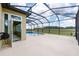 Backyard featuring a screened-in pool with a hot tub overlooking a lush green landscape at 9777 Sw 63Rd Loop, Ocala, FL 34481