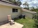 A view of the home's exterior, with patio, chair, and grassy backyard space at 9801 Sw 88Th Ter # B, Ocala, FL 34481