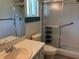 Well-lit bathroom featuring a shower with glass doors, a toilet, and a sink at 9801 Sw 88Th Ter # B, Ocala, FL 34481