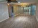 Spacious living room with laminate flooring, mirrored wall, and a ceiling fan at 9801 Sw 88Th Ter # B, Ocala, FL 34481