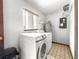 Functional laundry room featuring a washer, dryer, water heater, and a window for natural light at 10520 Sw 85Th Ter, Ocala, FL 34481