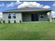 Back exterior view of a single-story home with a covered patio and large sliding glass doors at 10540 Sw 49Th Avenue Rd, Ocala, FL 34476