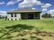 Back exterior view of a modern home with a covered patio and large lawn at 10540 Sw 49Th Avenue Rd, Ocala, FL 34476