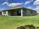 Back exterior view of a single-story home with a covered patio and large sliding glass doors at 10540 Sw 49Th Avenue Rd, Ocala, FL 34476