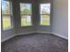 Corner bedroom featuring cozy gray carpet and a view of the outdoors through bright windows at 10540 Sw 49Th Avenue Rd, Ocala, FL 34476
