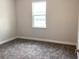 Neutral bedroom featuring gray carpet and a window, providing a bright and welcoming space at 10540 Sw 49Th Avenue Rd, Ocala, FL 34476