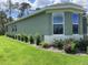 Side exterior of a modern home featuring large windows and well-maintained landscaping at 10540 Sw 49Th Avenue Rd, Ocala, FL 34476