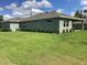 Rear exterior view of a modern home, showcasing a covered patio and lush green lawn at 10540 Sw 49Th Avenue Rd, Ocala, FL 34476