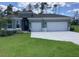 Charming single-story home with well-manicured lawn and a three-car garage on a sunny day at 10540 Sw 49Th Avenue Rd, Ocala, FL 34476