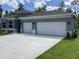 Modern home with a three-car garage, featuring manicured landscaping and a spacious driveway at 10540 Sw 49Th Avenue Rd, Ocala, FL 34476