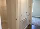 Bright hallway featuring white trim, doors, and neutral wall paint with wood-look flooring at 10540 Sw 49Th Avenue Rd, Ocala, FL 34476